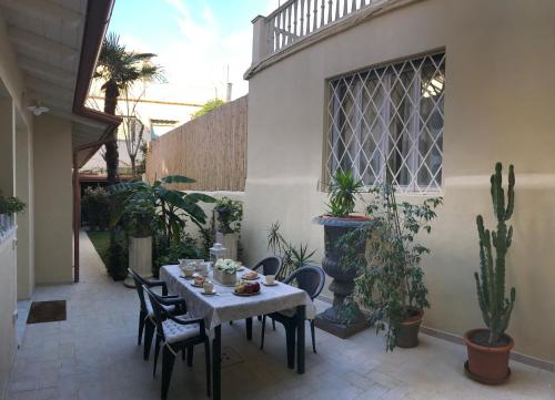 een patio met een tafel, stoelen en planten bij La casa di Anna in Viareggio