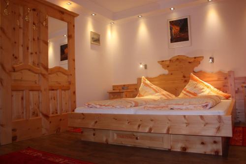 ein Schlafzimmer mit einem Holzbett in einem Zimmer in der Unterkunft Gasthof Gosausee in Gosau