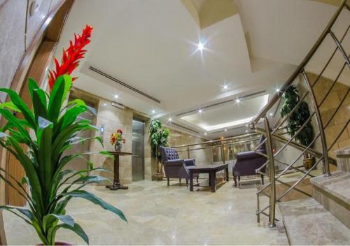 un hall avec des escaliers, des chaises et une plante dans l'établissement Al Joury Aparthotel, à Djeddah