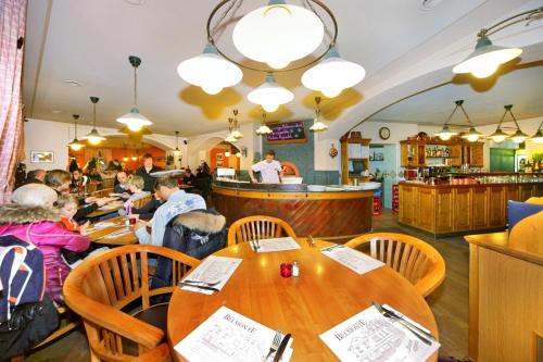 a group of people sitting at tables in a restaurant at Hotel pizzeria Belmonte in Špindlerův Mlýn