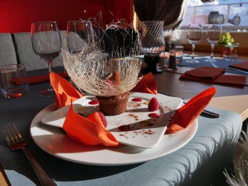 a table with a plate of food and wine glasses at Hôtel La Grande Lanière in Les Gets