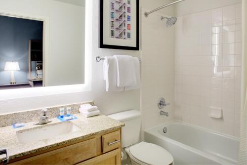 a bathroom with a sink and a tub and a toilet at Hyatt House Dallas Lincoln Park in Dallas