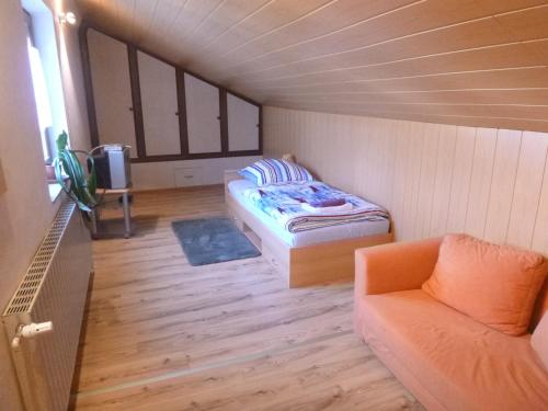 HasselrothにあるGästehaus Lindnerのベッドと椅子付きの小さな部屋です。