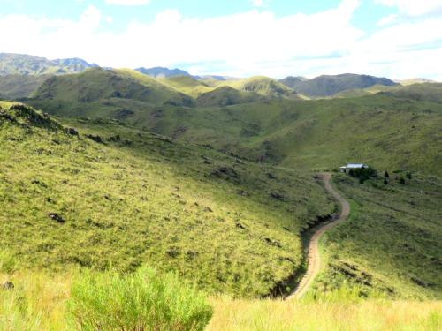 a winding road on a hill with mountains in the background at Estancia Altos del Durazno in Estancia Grande