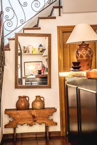 a room with a mirror and a refrigerator and a table at Hostal Goya II in Carbonero el Mayor