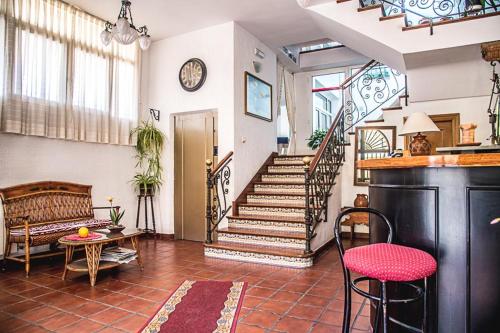 a living room with a staircase and a table and chairs at Hostal Goya II in Carbonero el Mayor