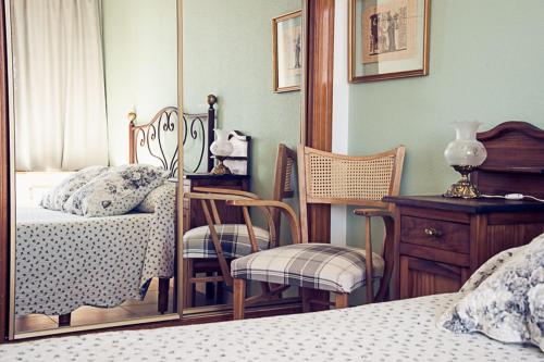 a bedroom with a bed and a chair and a desk at Hostal Goya II in Carbonero el Mayor