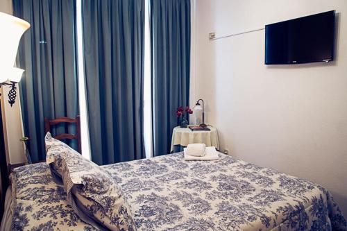 a bedroom with a bed with blue curtains and a table at Hostal Goya II in Carbonero el Mayor