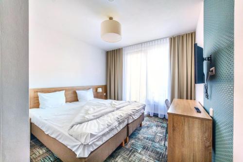 a hotel room with a bed and a desk at Siesta in Grzybowo
