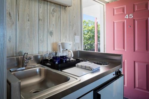 a kitchen with a sink and a pink door at The Vista in Gloucester