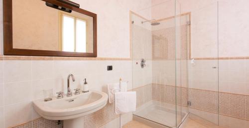 y baño con lavabo y ducha acristalada. en B&B Residence il Ciliegio , Via Villa Superiore 93 Luzzara, en Luzzara