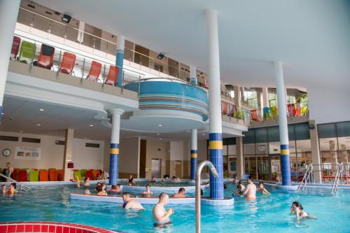 a group of people in the water in a swimming pool at Sport Hotel in Tatabánya
