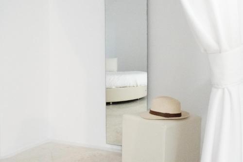 a hat sitting on a table in front of a mirror at Hotel Thireas in Fira