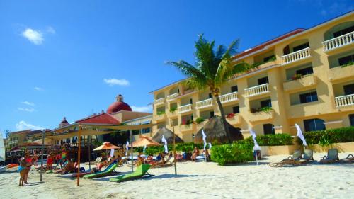 a hotel on the beach with people sitting on the sand at Tropical apartment in Cancún