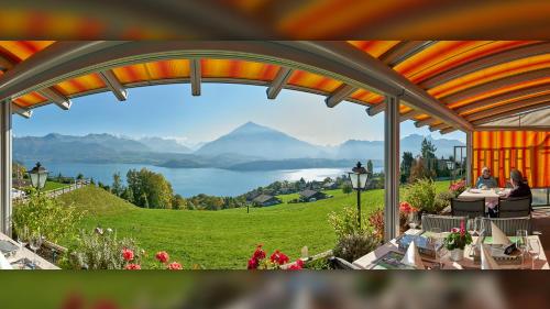 a patio with a view of a lake and mountains at Hotel Restaurant Panorama in Aeschlen