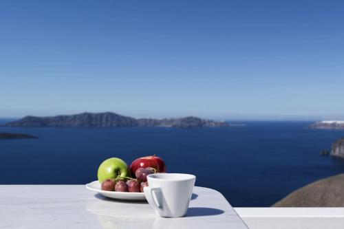 a plate of fruit and a cup on a table at Hotel Thireas in Fira