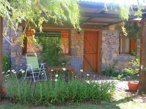 a chair and a table in front of a house at Estancia Altos del Durazno in Estancia Grande