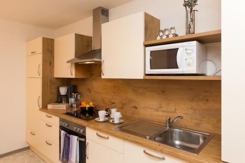 a kitchen with a sink and a microwave at Kärnten Apartment Turnersee in Sankt Kanzian