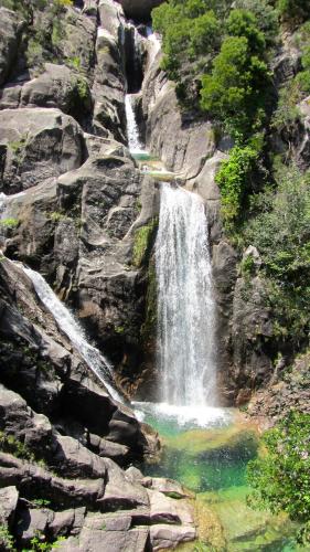 a waterfall on the side of a rocky mountain at Casa do Charco Peneda Gerês in Parada