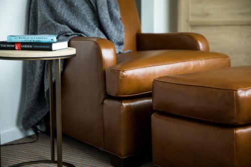 a chair and a table with books on top of it at The Study at University City, Study Hotels in Philadelphia