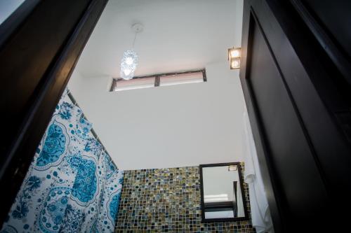 baño con espejo y cortina de ducha azul y blanco en Vacation Rental - Upper Floor Room at Casa Cocoa, en Cozumel