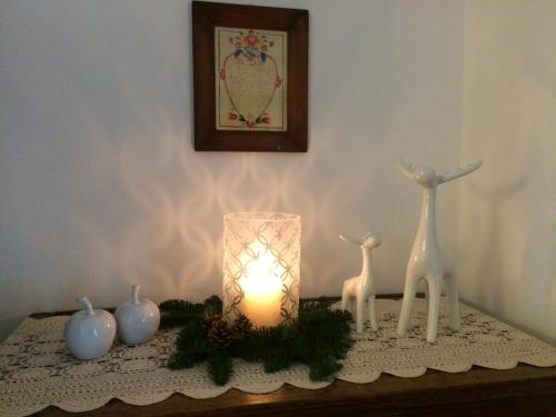a candle sitting on a table with two deer figurines at La Stube de Marinette 5 étoiles in Hipsheim