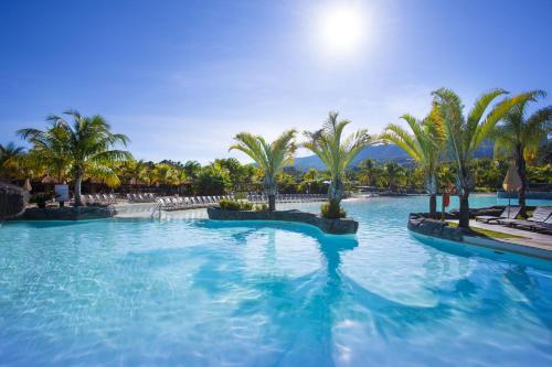 a swimming pool with palm trees in a resort at Rio Quente Resorts - Eco Chalés in Rio Quente