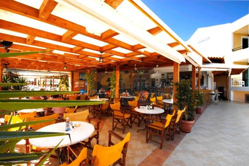 an outdoor patio with tables and chairs and a restaurant at Vanessa Hotel in Kalamaki