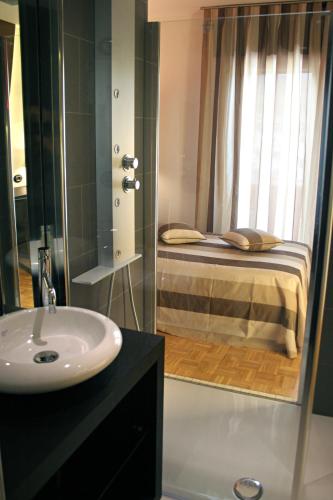 a bathroom with a bed and a sink and a mirror at Hotel La Pergola in Grezzana