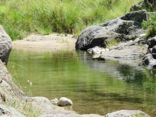 a stream of water with some rocks and grass at Estancia Altos del Durazno in Estancia Grande