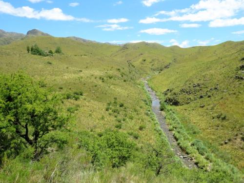 a winding mountain road through a green valley at Estancia Altos del Durazno in Estancia Grande