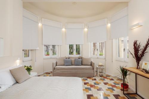 a bedroom with a bed and a couch and windows at San Giorgio Boutique Rooms in La Spezia