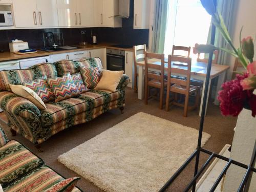a living room with a couch and a table at Woodlands Holiday Apartments in Lytham St Annes