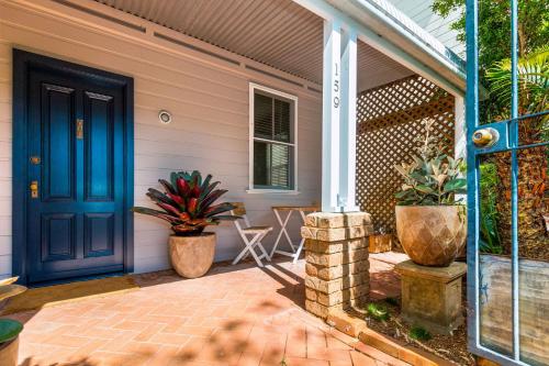 a house with a blue door and a patio at Jetty House in Coffs Harbour