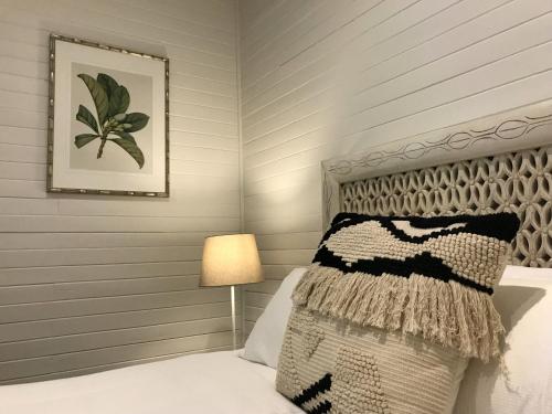 a bedroom with a bed with a pillow and a lamp at Jetty House in Coffs Harbour