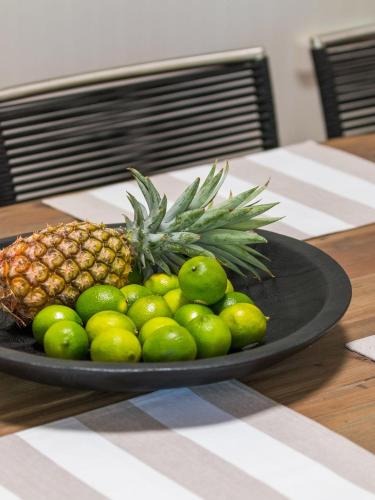 a plate with a pineapple and limes on a table at Jetty House in Coffs Harbour