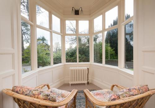 an empty room with two chairs and windows at Banoge House in Donaghcloney