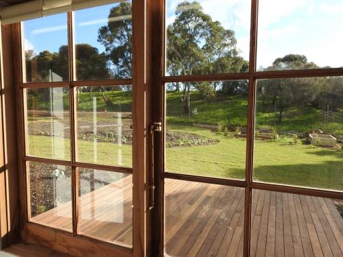 an open window with a view of a wooden deck at Grape Pickers Cottage in McLaren Vale