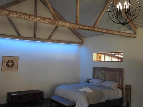 a bedroom with a bed and a chandelier at Grape Pickers Cottage in McLaren Vale