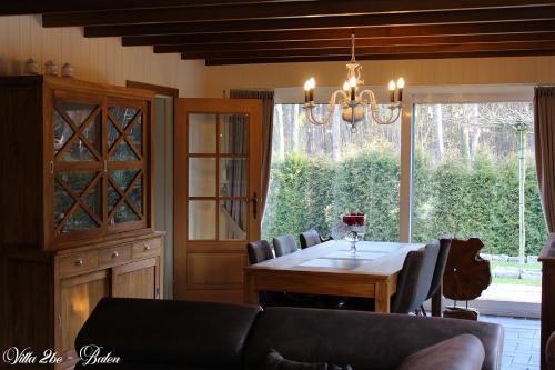 a dining room with a table and a couch at villa 2be in Balen