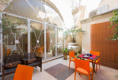 a patio with orange chairs and a table at Corte dei Memoli in Lecce