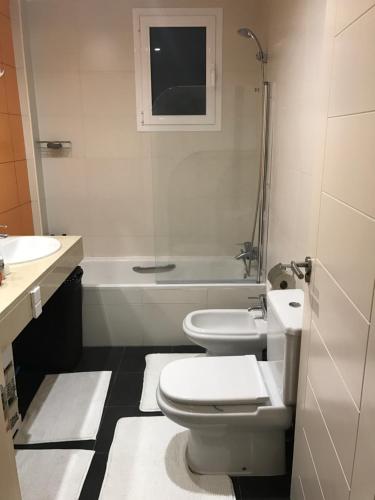 een badkamer met 2 toiletten, een wastafel en een bad bij Estepona valle romano in Estepona