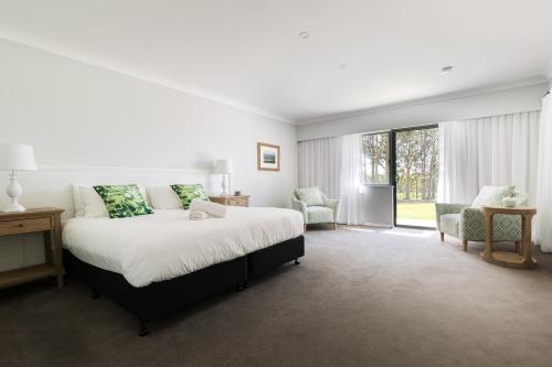 a bedroom with a large bed and a large window at Nu Leaf Retreat in Pokolbin