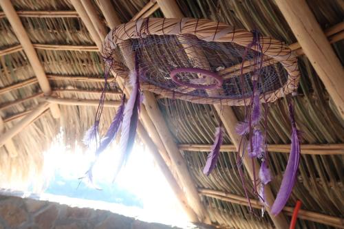 a wicker basket hanging from the ceiling of a thatch hut at Hotel Sal de Mar in San Agustinillo