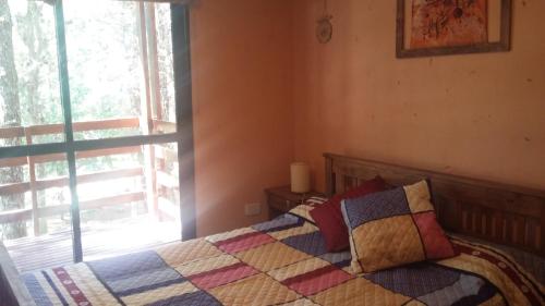 1 dormitorio con 1 cama con edredón en Bluingrin en Mar de las Pampas