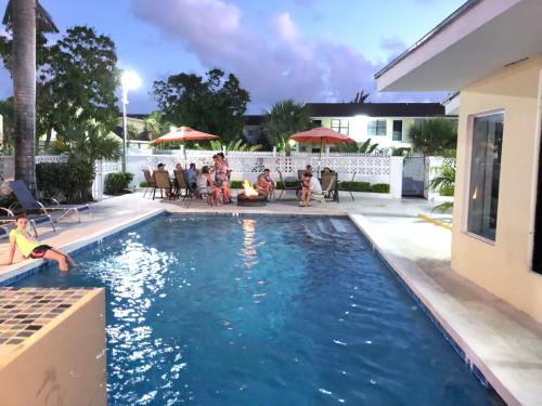 a group of people sitting around a swimming pool at Colony Club Inn & Suites in Nassau