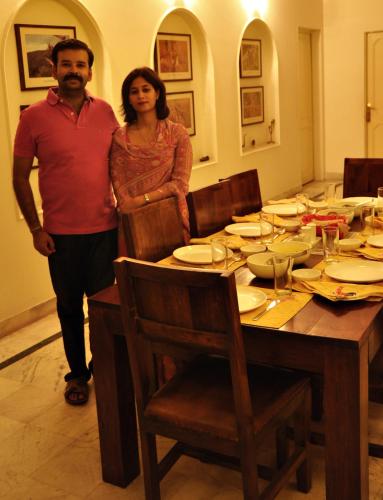a man and a woman standing in front of a table at Pratap Bhawan Homestay in Jaipur