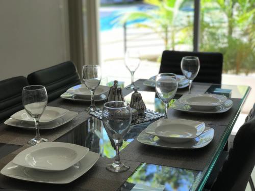 a table with plates and wine glasses on it at Beach Haus-Punta Estrella in Playa del Carmen