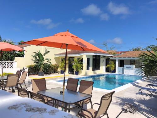 a table with an umbrella next to a swimming pool at The Oasis Retreat in Nassau