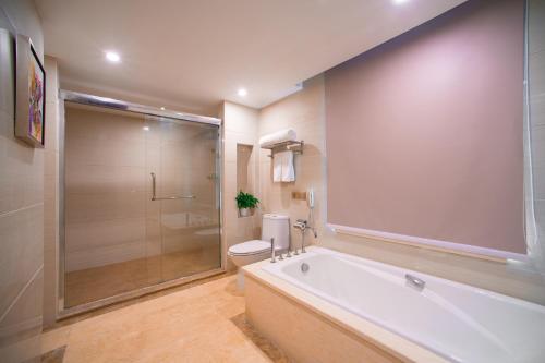 a bathroom with a tub and a toilet and a shower at Guangzhou Jin Wan Li Business Hotel in Guangzhou